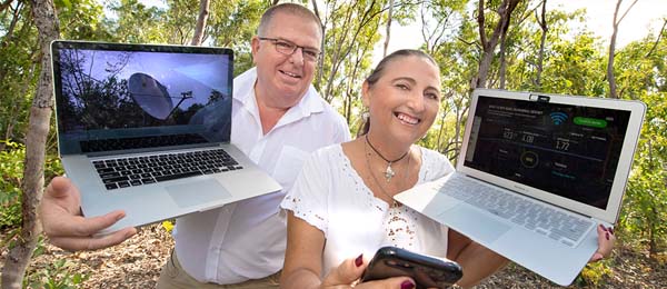 Researchers David Murtagh and Marianne St Clair holding laptops and a mobile phone